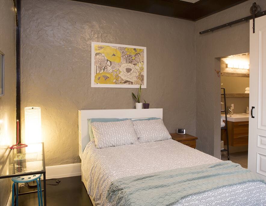 Master bedroom with a full sized bed and a private bath