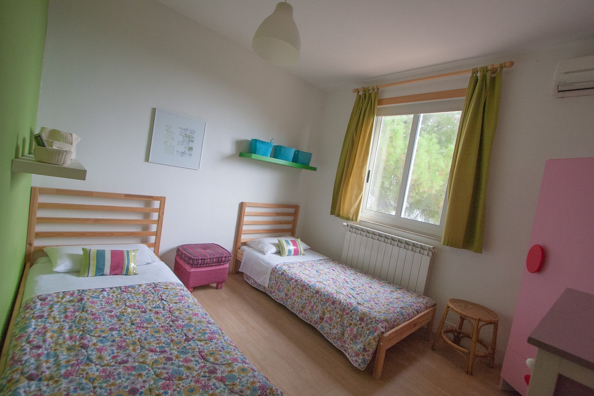 A bedroom with 2 single beds and aircon.