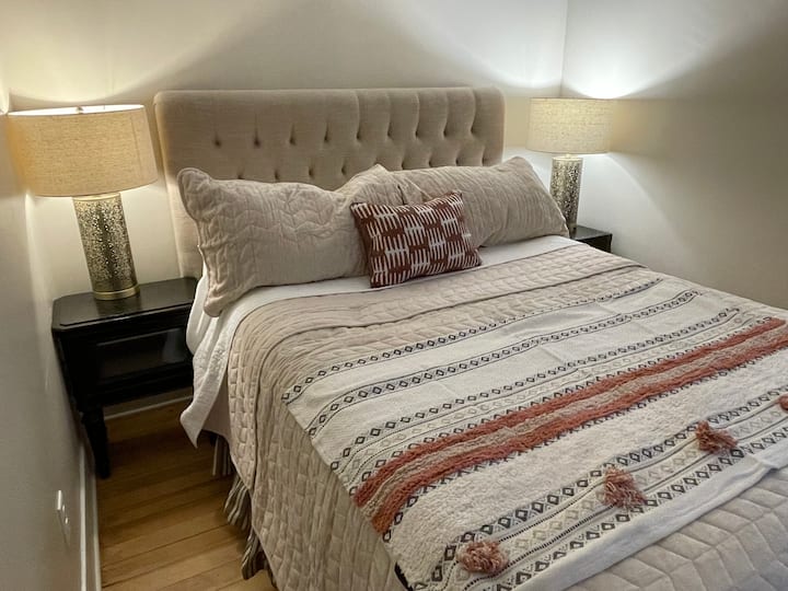 标准双人床卧室，配有电视和奢华的床上用品。