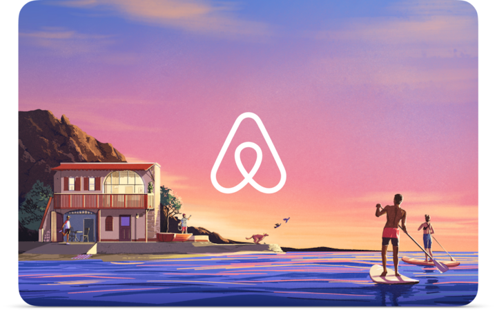 Illustration of two people on stand up paddle boards making their way back to a house on the beach. They are surrounded by a purple and pink sunset. The Airbnb logo is in the center.