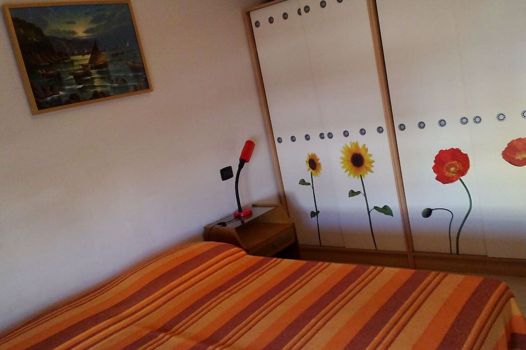 Stanza con letto matrimoniale, comodo armadio e accesso al balcone.