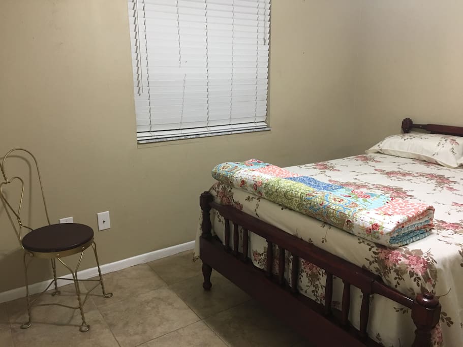 To the upper left a medium window and to the lower left a chair and to the right the bed for two