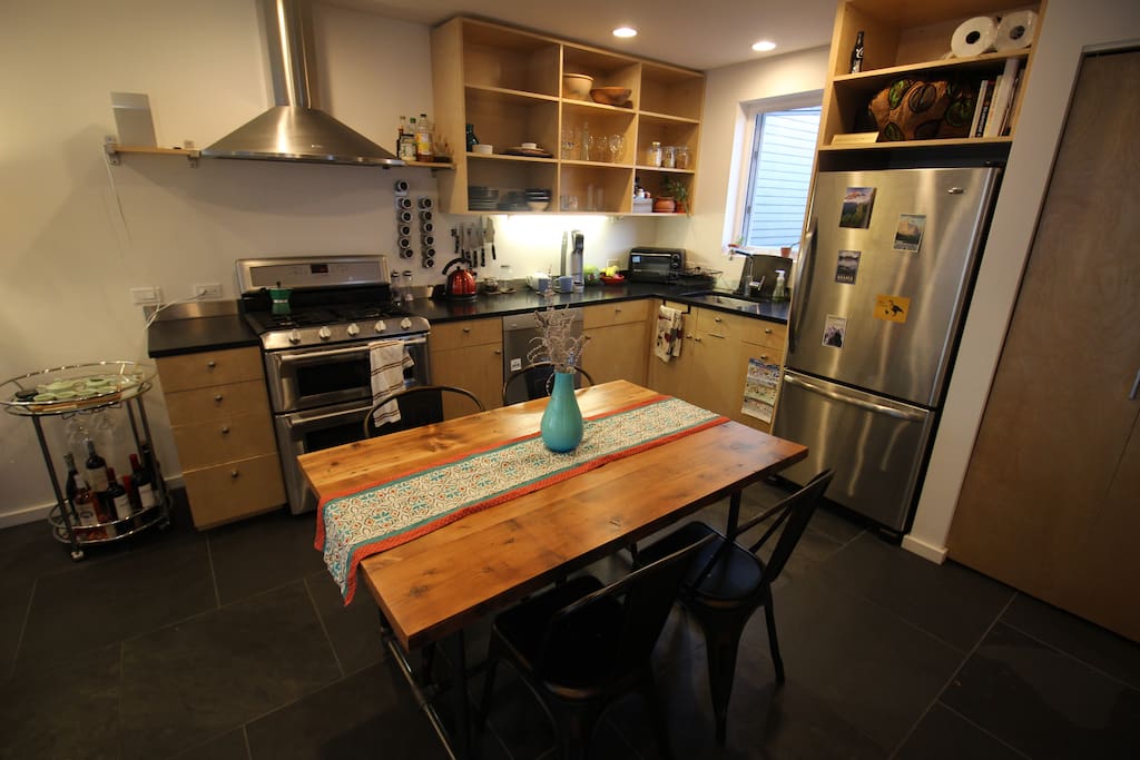 Fully stocked open plan kitchen with reclaimed wood hand-made table