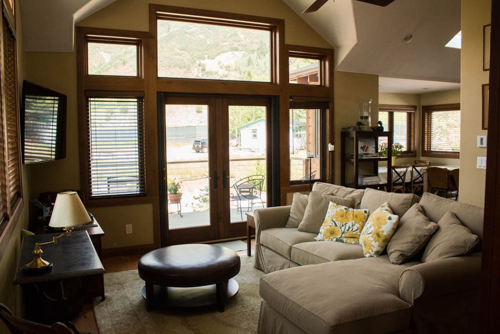 Living room with large couch and french doors that open out onto the deck.