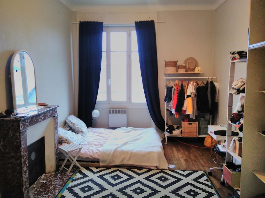 Chambre spacieuse sur parquet et cheminée décorative