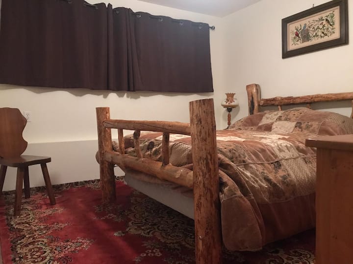 Larger bedroom with a beautiful wooden bed handcrafted by our friend Hannah.
