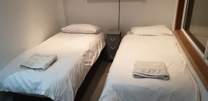 Vaskerum nedenunder med 2 enkeltsenge .