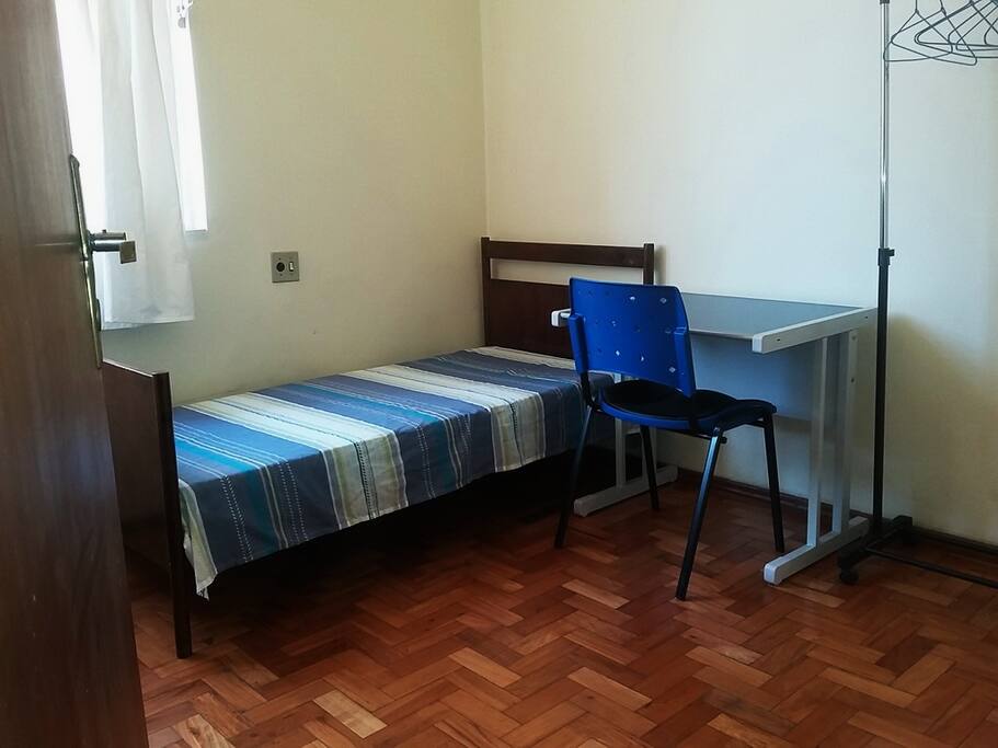 Quarto de solteiro com mesa, cadeira e closet