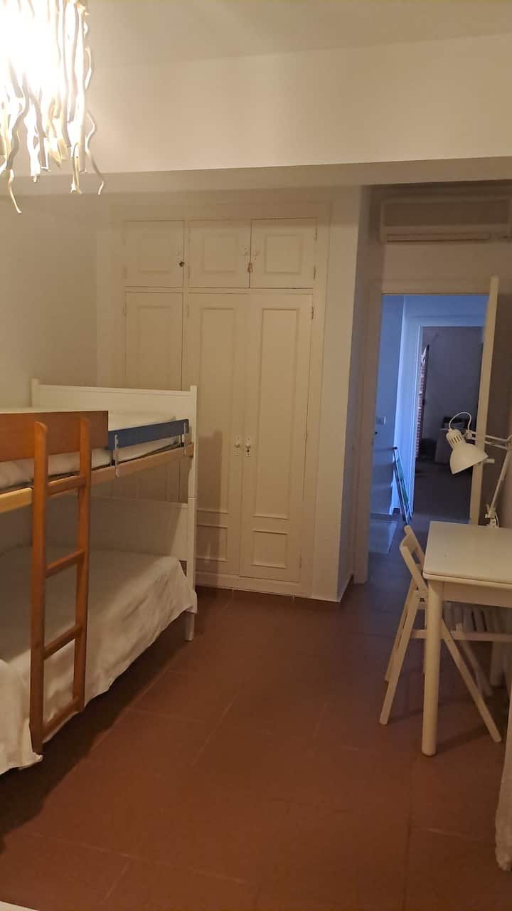 Spálňa s manželskou posteľou, samostatnou posteľou a poschodovou posteľou.