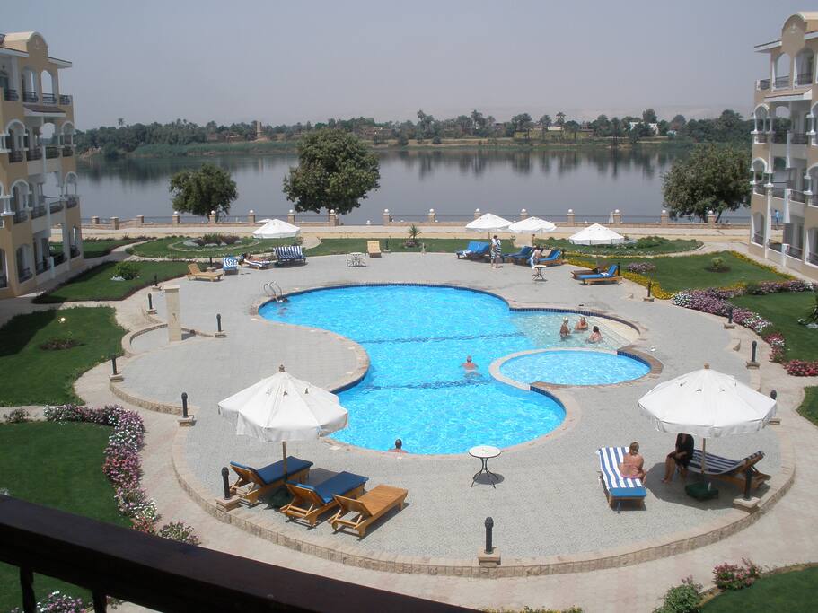 large swimming pool with large sundecks set in beautiful gardens