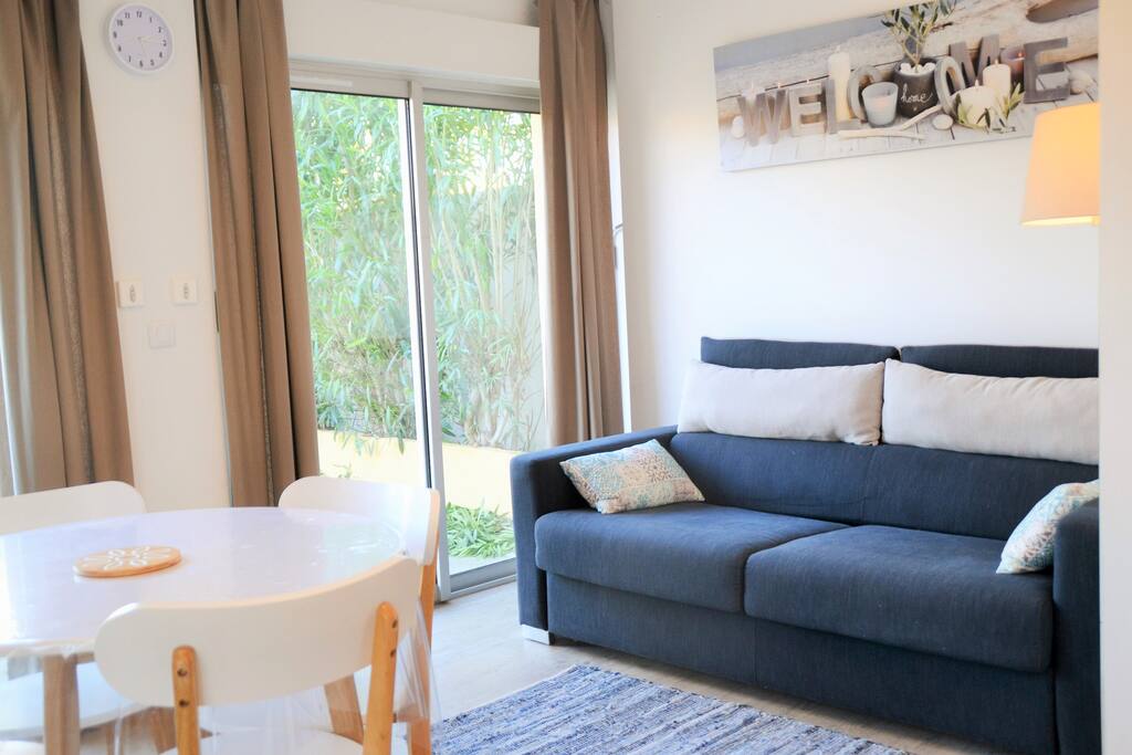 Le salon lumineux avec ses 2 baies vitrées donnant sur la terrasse
