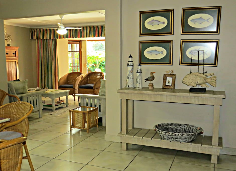 From the lapa you walk through the front door into an open-plan lounge/dining room area with a round dining room table that can seat 6 people.