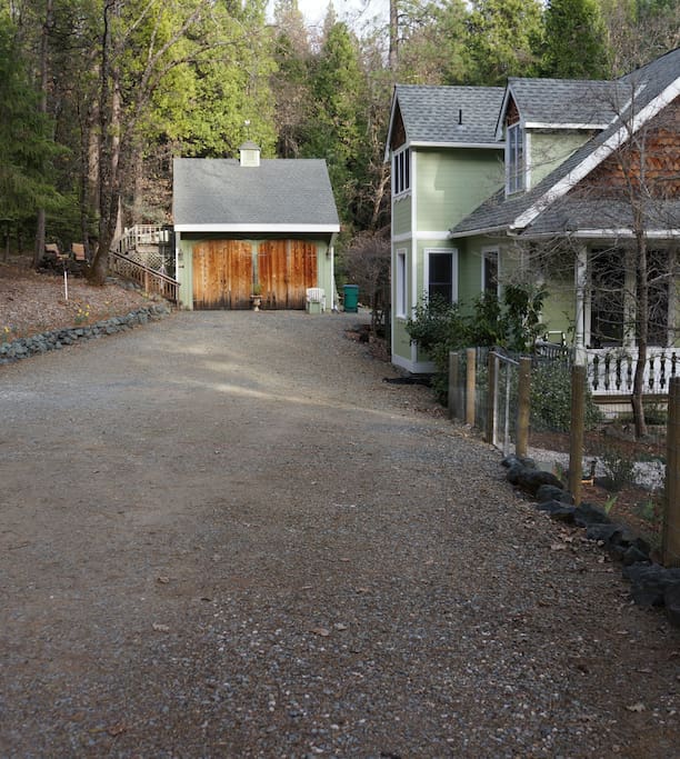 The driveway with plenty of parking. Guest cottage is above garage, separate from the house.