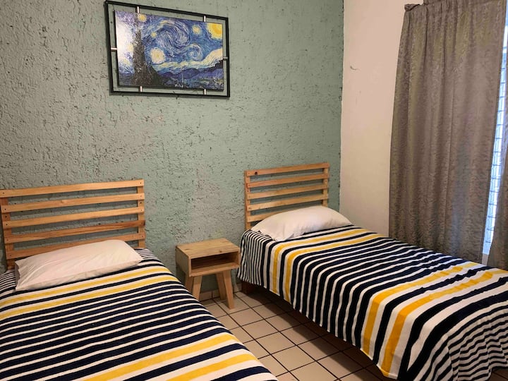 Bedroom with two single beds, dresser and ceiling and mobile fan, large closet.