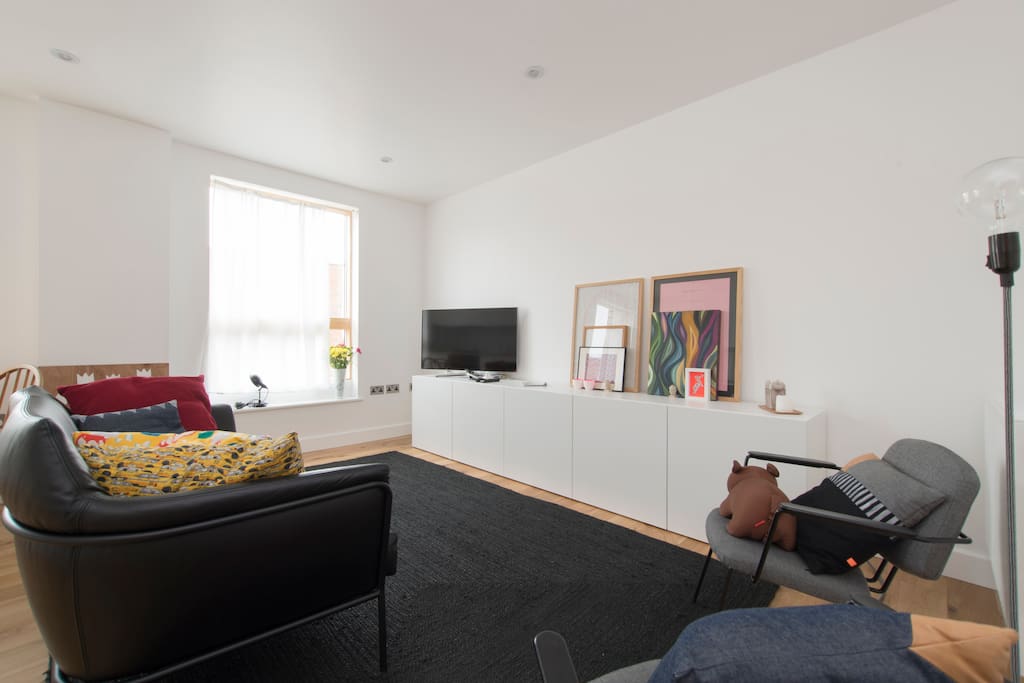 Bright seating room with TV and city views.
