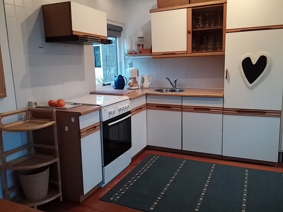 Compleet ingerichte keuken met magnetron, aparte oven, grote koelkast met diepvriesvak.