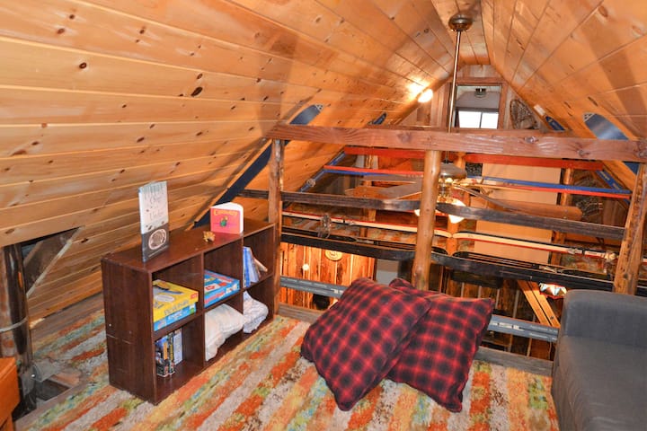 Children's loft area, sofa pulls out to a single bed, TV with VHS movies.