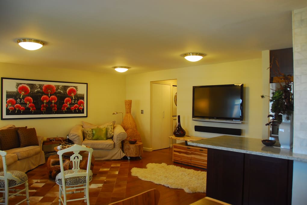 The living room area , 52” TV , free washer and dryer located at the side hallway ,an eat in counter by the side of the kitchen that can be used as a work station or as an eat in counter