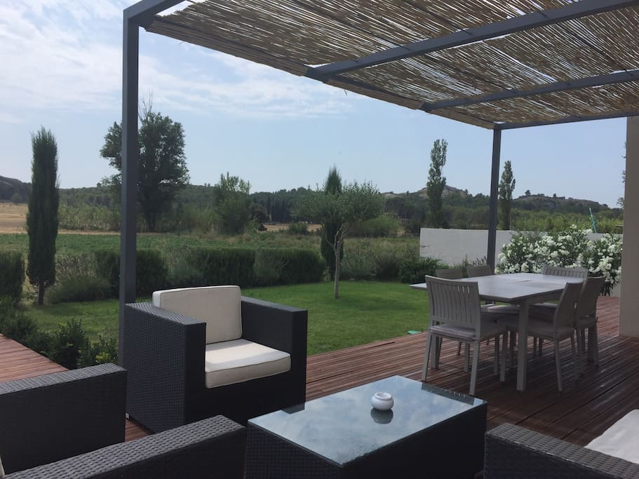 Terrasse ombragée avec son espace repas et petit salon extérieur