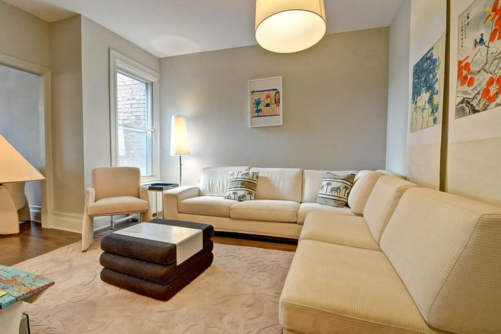 Elegant & Bright living room with HD TV and Apple TV. Lovely view of the living room with a large "L" sofa. Enjoy a memorable night with family and friends.