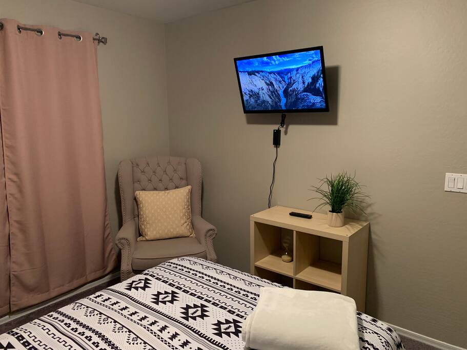 This picture shows the wall mounted 32” tv equipped with chrome cast. It also shows the tufted armchair perfect for reading or unwinding from a long trip