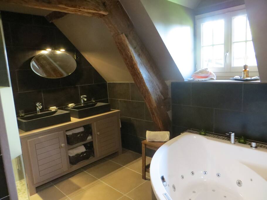 2 vasques en pierre, bain balnéo " la salle de bain très moderne avec douche à l'italienne et une grande baignoire à bulle entourée de petites bougies, idéale pour se détendre après s'être promené dans les champs, avoir fait du tir à l'arc ou du canoë sur l'étang" Thomas