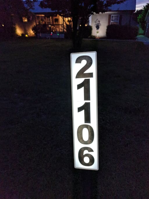 Lighted house number next to the street.