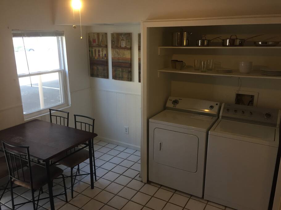 Dinner table, exposed dishes and full size washer and dryer.