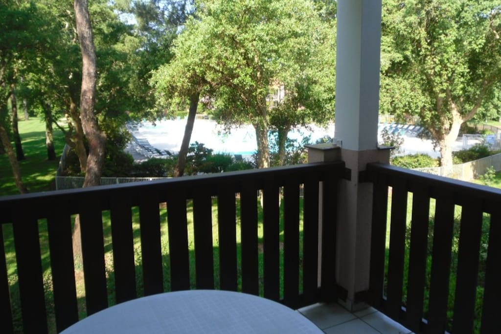 La terrasse ombragée avec vue sur le parc et la piscine