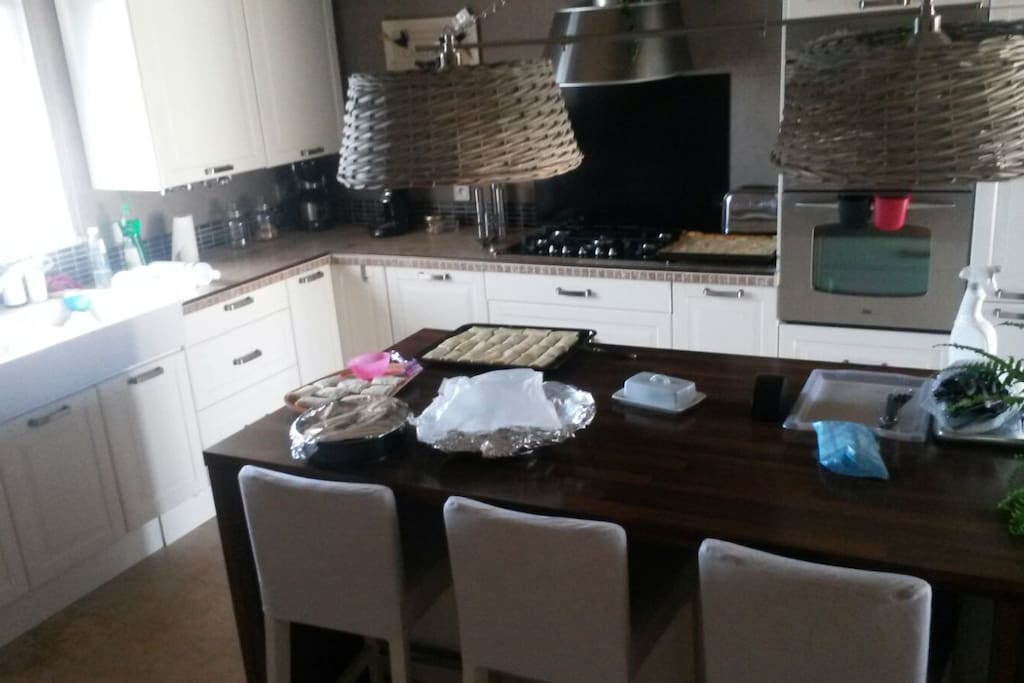 grande cuisine avec un ilot centrale et une table accueillant 5 personnes