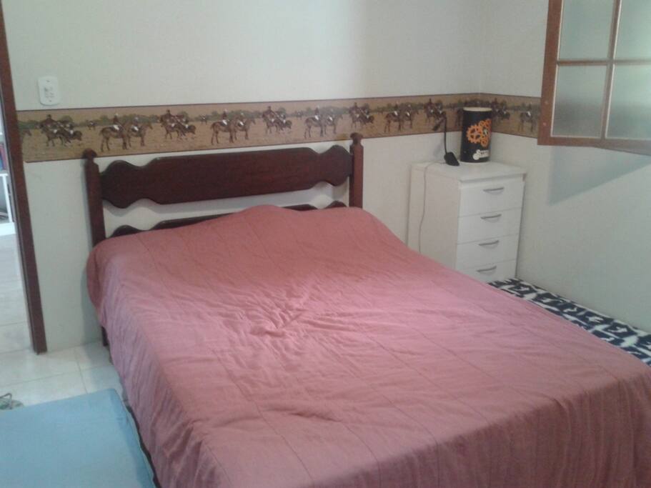 Cama confortável, criado mudo. Cabem três colchonetes ao redor da cama.