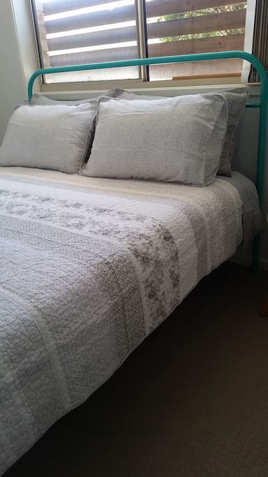 Comfortable queen sized bed with beautiful bedding