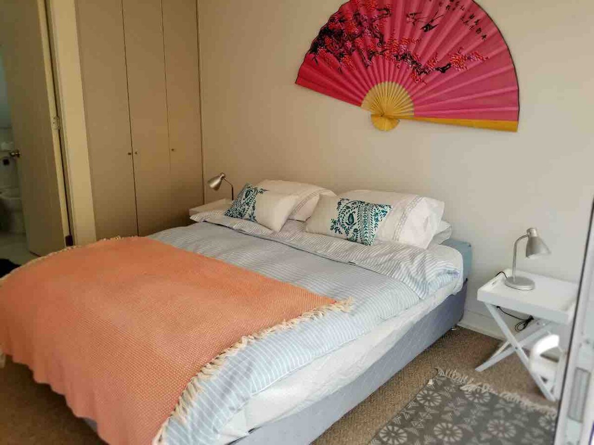 غرفة نوم مزدوجة مشرقة ودافئة بسرير مزدوج لشخصين، اخرج إلى الشرفة.