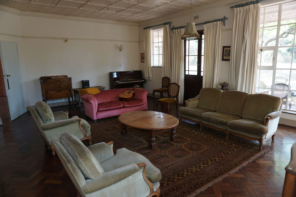 A spacious sitting room with lovely lighting and a piano