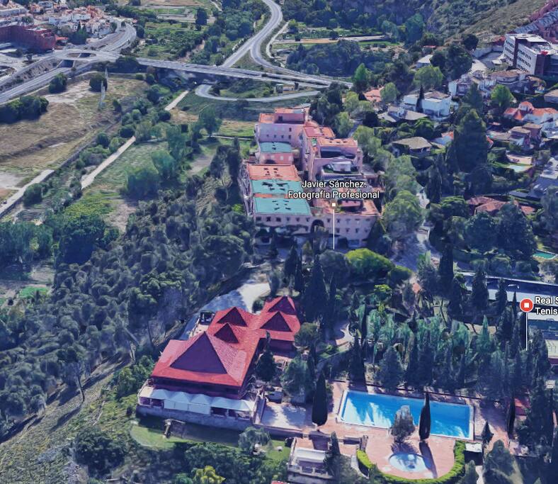 En primer plano la piscina y el salón piramidal del Club de Tenis.