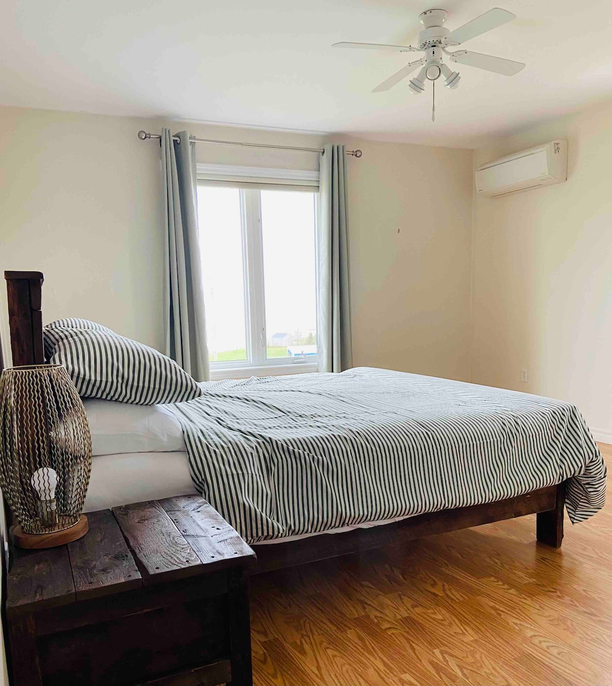 King bedroom with handmade reclaimed wood bed and views of Rustico Bay