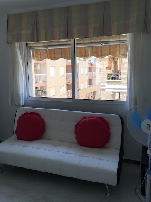 Salle à manger avec canapé , belle table, chaises, armoires, ventilateur plafonnier, ventilateur sur pied, airco, TV haute définition.