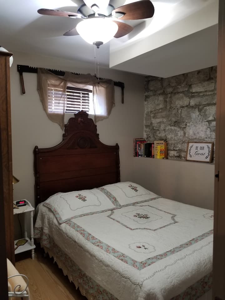 Bedroom #2 queen bed, and showing original 22-inch thick limestone foundation
