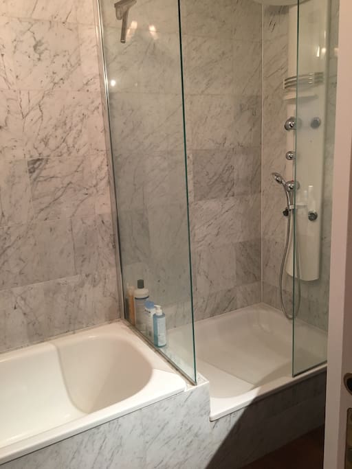 La salle de bain avec douche et baignoire