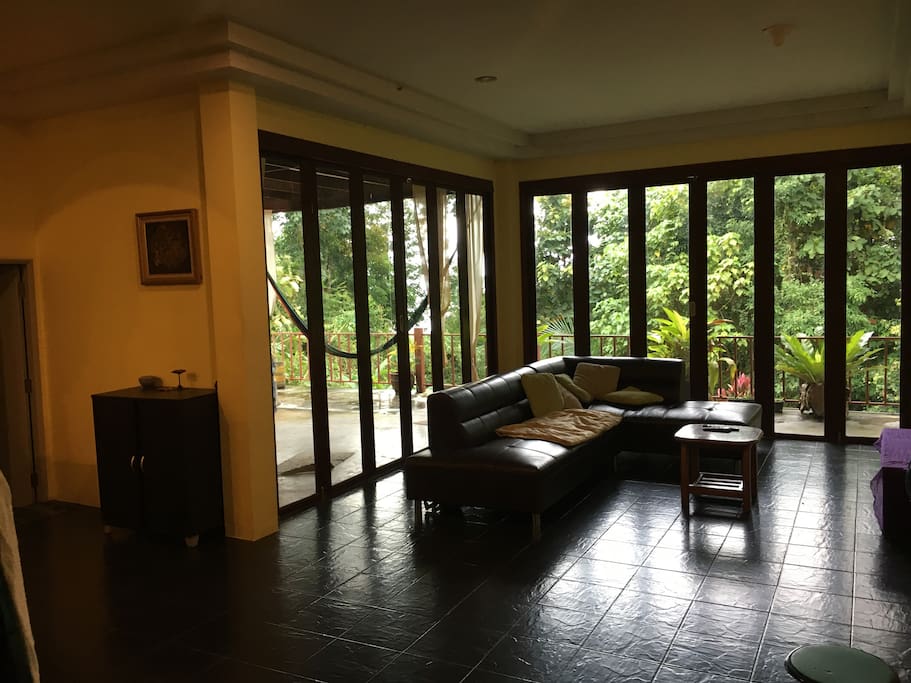 Spacious shared sitting room with large flatscreen T.V,doors open out to hammock seated chill out terrace and balcony ,surrounding sea and jungle views .