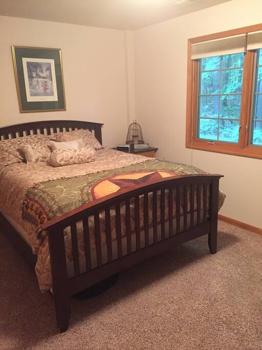 Queen size bed with wooded view and wildlife.