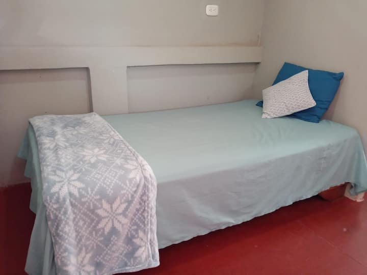 habitación con cama individual, el espacio es abierto, se conecta con la habitación principal, no hay puertas.
