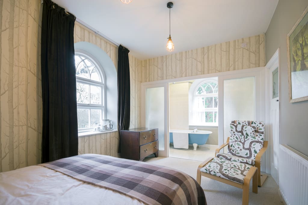 A bathroom separated from the bedroom by frosted sliding doors.