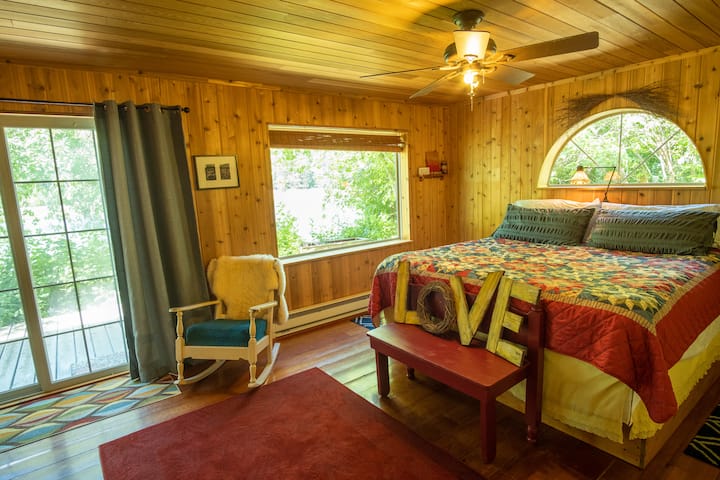 Chumba cha kulala 1 (chumba kikuu cha kulala) na maoni ya mto na upatikanaji wa staha ya kando ya mto.