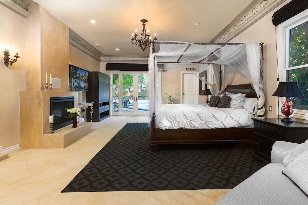 The 1200 square foot master suite features French doors that open to the pool/patio area, a cal-king canopy bed, a romantic LED lit fireplace, 50" flat screen tv, and ample wardrobe space in addition to a walk-in closet.