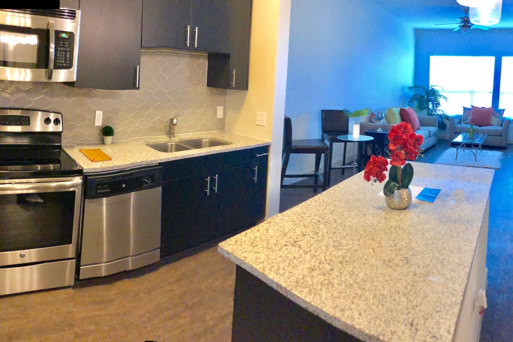 Kitchen island with granite counter tops, built-in microwave , electrical stove top , oven , sink with disposal, stainless still fridge, dishwasher