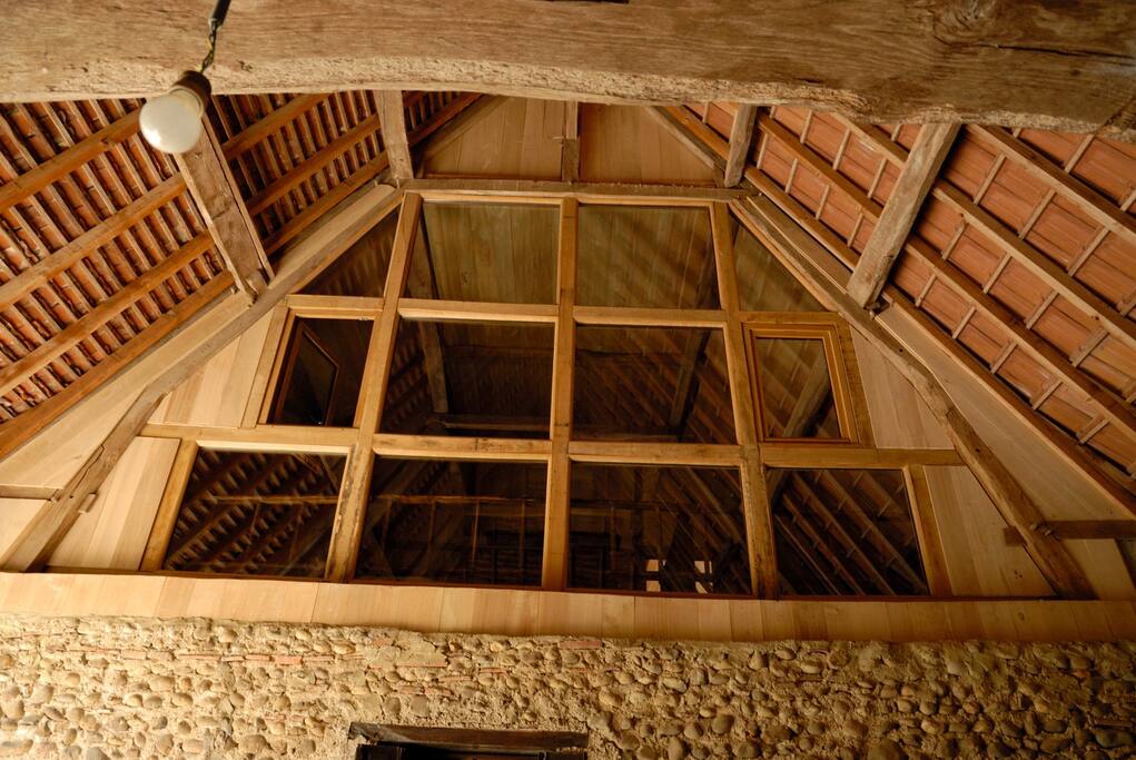 Chambre "Sack" avec son mur en vitres pour admirer la charpente et capter la lumière.