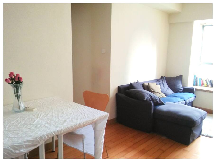 View from Entrance. Living Room Couch & Dining Area. Two Chairs + Two Stools Available for the Dining Table.