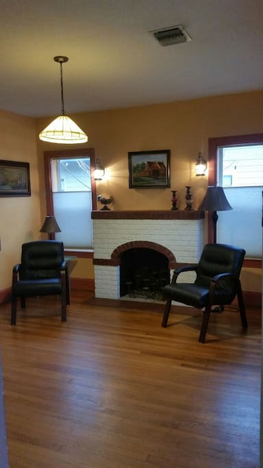 Sitting room with working fireplace. Wood floors throughout the house.