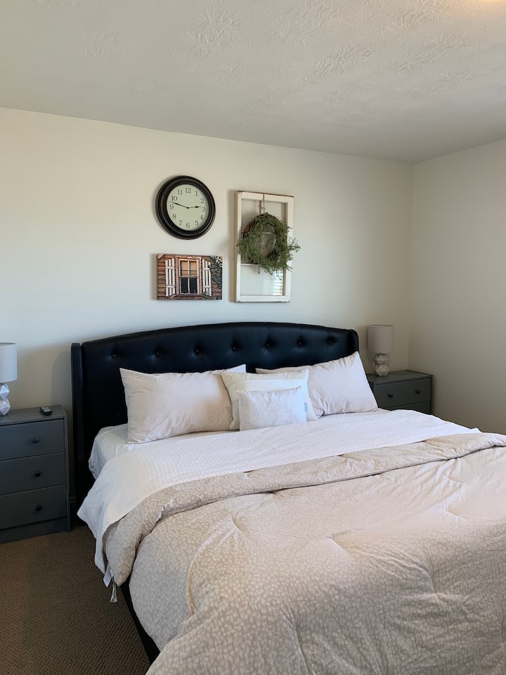 غرفة نوم رئيسية مع تلفزيون ذكي 45 بوصة وحمام داخلي كامل.